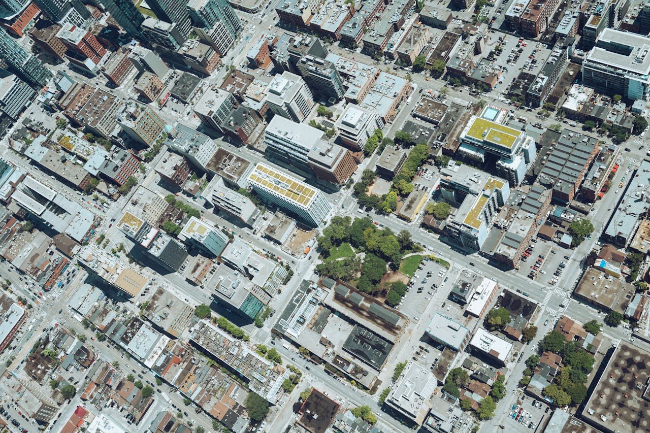 Drone view of city district with typical contemporary building and streets on sunny day